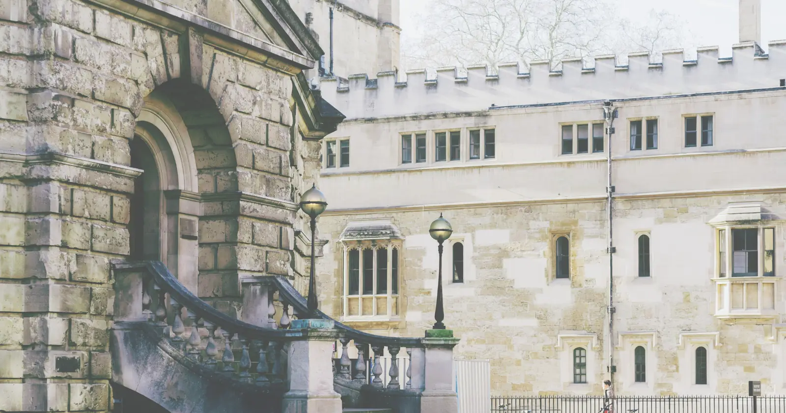 An arched doorway and balustraded stone staircase at an Oxford college in soft daylight